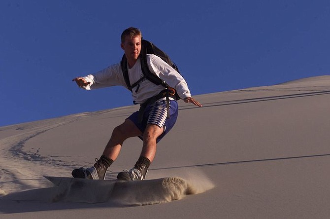 Jeremy Evans carves down Sand Mountain (Challenge Number 3) near Fallon on Day Five of the Nevada 10-in-10 Challenge Friday, Aug. 9, 2002. The four Nevada Newsmen also completed Challenge Number 4 (off-road skateboarding across the Black Rock Desert near Gerlach.) Photo by K.M. Cannon