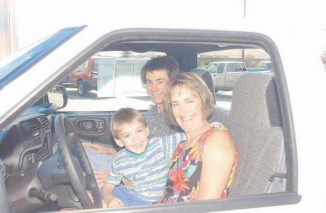 Pam Leiken sits with her son, Michael Leiken, 5, and husband, Ron Leiken, in their ne Sonoma pick-up truck that they won during the Make-A-Wish Foundation Reno Duck Races. Pam bought one duck for $5 at a mall booth and won the race. Photo by Brian Corley