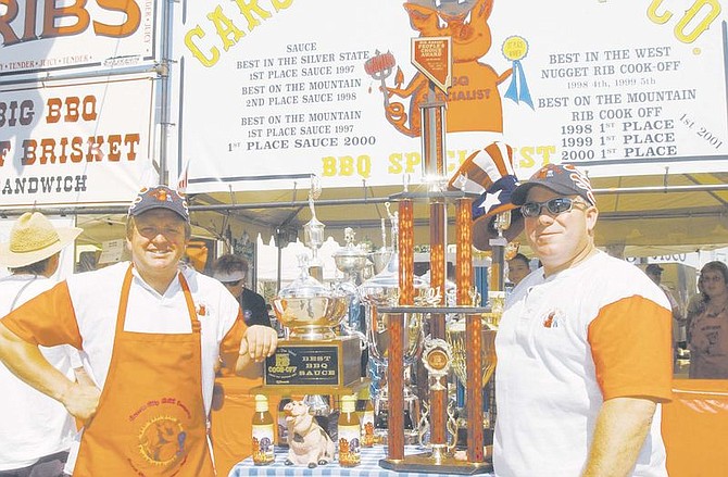 Phil Hyatt, left, and Duane Felker stand next to their trophies in front of their booth at the Reno Rib Cook-off. Last year they were the first ever to win two first place trophies, Best Sauce and People&#039;s Choice. Photo by Brian Corley