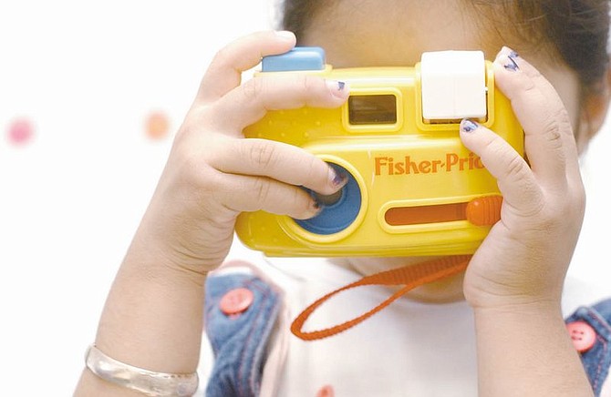 Pre-kindergartner Jocelyn Adrian,4, gets in touch with her inner shutterbug at the pre-k class at Mark Twain Elementary Tuesday morning.  photo by Rick Gunn