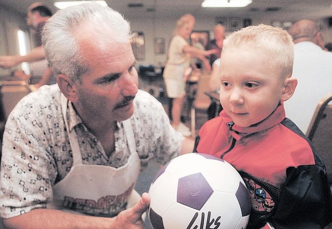 Brian Corley photoJim Smolenski, left, and 3-year-old Daniel Morrison, take a moment Friday to give Daniel a soccer ball at a spaghetti feed Friday to benefit the little boy who is undergoing cancer treatment. The dinner at the Elks Lodge raised $3,000 toward Daniel&#039;s medical bills.