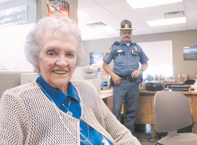 Brian Corley photo.Beth Clark, an 89-year-old Nevada Department of Public Safety volunteer, sits at her desk Monday as Nevada Highway Patrol Sergeant Ed Harney stands in the back.