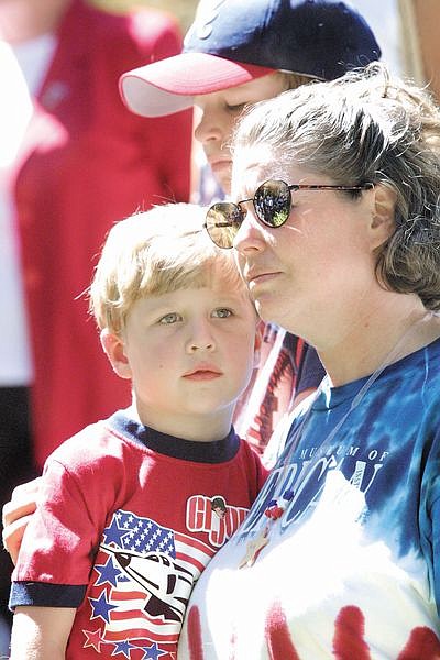 Terri Domitrovich and her sons Adam, 4, and Nicholas, 8, rear, listen to the ceremony at the Capitol on Wednesday afternoon.  Gov. Kenny Guinn declared Sept. 11 &quot;Patriot Day&quot; in the state of Nevada during the ceremony which drew more than 500 people.