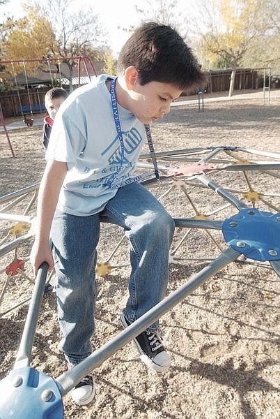 Arturo Soriano, 8, plays on top of a Jungle Jim during the After School Boys and Girl Club at Empire Elementry School. Thursday workers with the Boys and Girls Club recognized the workers of the satelite club. Photo by Brian Corley