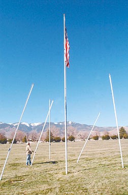 Rex Jennings volunteer for the Lone Mountain Cemetery stands next to the flagpoles in the Vets graveyard that were vandalized Tuesday night.  Photo by Rick Gunn