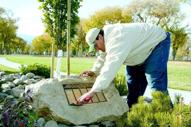 Rick Fowler/ The Nevada Appeal Daniel Sanchez of the Parks Department seals a new plaque at the Vetrans Memorial in Mills Park on November 6, 2003.