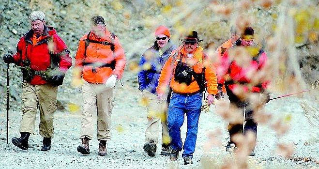 BRAD HORN/Nevada Appeal Carson City Search &amp; Rescue workers walk back to their cars after searching an area near Moundhouse Saturday.