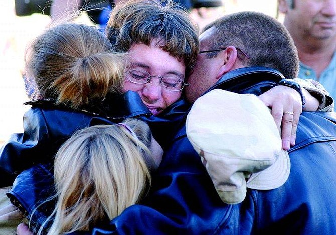Sgt. Tanya Leonard hugs her Family Wednesday morning at the Carson City Airport after returning from Iraq. She is show hugging her husband Steven and her daughters Britney, 9, (on left) Sydney, 11, and Sierra, 9 (not shown).