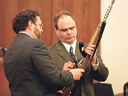 Defense attorney Tod Young and murder defendant Anthony Echols discuss the murder weapon Monday, as Echols prepares to demonstrate for the jury how he shot contractor Rick Albrecht twice in the head Aug. 5, 2000.  Echols claims the shooting was an accident.