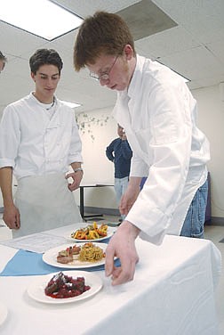Tim Suchsland, 17, puts the final dish out for display to be jugded on plate presentation at Carson High School Friday. The students had to make their own menu consisting of six dishes to be judged on tast and plate presentation. Photo by Brian Corley