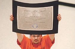 CHS graphics student Steve Tindle holds up his winning design for diplomas Friday afternoon at Carson High School.   photo by Rick Gunn