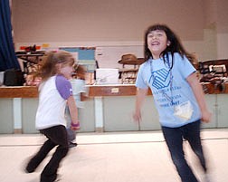 Kassy Nays, 7, left, and Frida Srabin, 7, run through the Empire Elementary School Gym Tuesday after school at the Boys ad Gilrs Club. The satelite program has recieved additional funding to continue children&#039;s activities at the school. Photo by Brian Corley