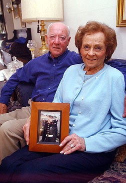 Kenneth Charipilloz Sr., left, and Alice Charipilloz hold a picture of their grandson, Sgt. Graham Collins, who has been in the Marine Corps for eight years and was deployed to the Persian Gulf two weeks ago. Collins is at least three quarters of the way to Baghdad with his unit and continues to advance on the city. Photo by Brian Corley