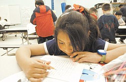 Marisol Lopez, 6, studies a word puzzle during Power Hour at Empire Elementary Thursday afternoon.