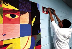 Edwin Seiler, 14, works at Carson Middle School Monday hanging pieces of art for the school&#039;s 4th annual art show.  The show will be on display throughout today.