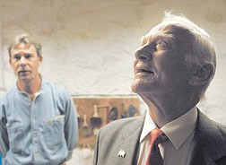 Buzz Aldrin looks around the work room where inmates carve and paint sandstone rock into beautiful sculptures. Inmate and artist Billy Beck watches.