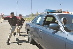 Homer Dagdagan, left, 28, of Carson, and Brandon Randall, 23, of Sparks, race around a patrol car during the emergency vehicle operations course of the Western Nevada State Peace Officer&#039;s Academy Sunday at WNCC.