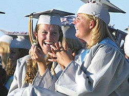 Melanie Reale, left, laughs with Rachel Hurt during the Dayton High School Commencement on Thursday night.