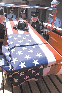 Paul Webster, from left, and Don Blanchard, of Warren Engine Fire Co. No. 1, lift the casket of Dean Cheney into one of the company&#039;s fire trucks.