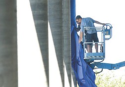 Event Source Production sound workers Kyle Rothchild, left, and Josh Procaccini hang a sheet of sound dampening material on  a column at the Pony Express Pavillion Tuesday afternoon. photo by Rick Gunn