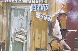 Dan Cole, 22, of Reno, runs into the bank with a stick of dynamite Saturday at Mills Park. Cole plays the part of a bad guy in the &quot;Gunfighters Show&quot; at the Carson Rendezvous.