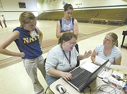 Girls State Junior Counselors, from left, Kadee Jo Carpenter, Danielle Simpson and Angela Galli work with Senior Counselor Anji Peterson, center front, on Wednesday afternoon at the Stewart Gym.  The Girls State campers were evacuated to the Stewart facility after the brush fire on Spooner Tuesday.