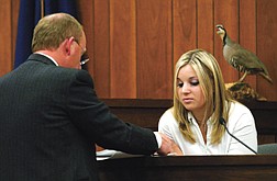 Alane Dockstader former girlfriend of murder suspect Chris Fieghan, looks over evidence from defense attorney Richard Young during Fieghans murder trial  in Douglas County on Thursday. Fiegehen stands accused of killing Dockstader&#039;s stepfather and shooting her mother Feb. 10, 2002.