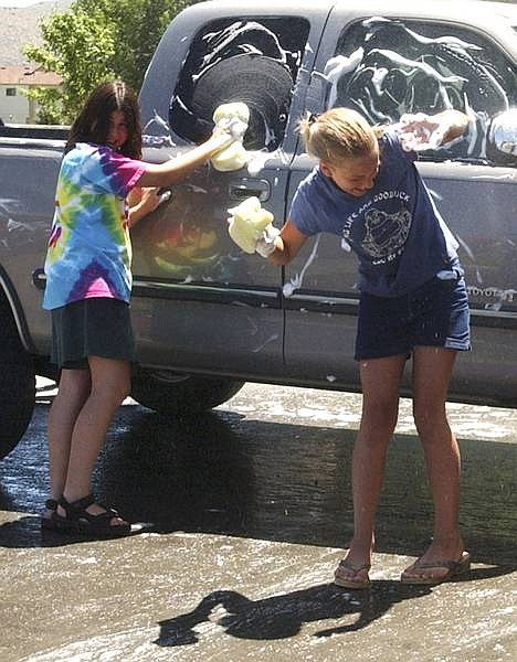 photo by April HeathElise Sala, left, and Katy Runde, both 13, keep cool in the mist during a car wash Wednesday to benefit the Carson City Recreation Department&#039;s Trailblazers Summer Kamp program.