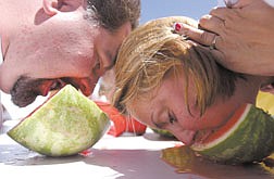 Bobbi May, left, of the Harley Davidson team, and Michael Caldare, of Carson, race to finish their slice of watermelon in this seed spitting contest at Carson High School Saturday.