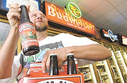A Ben&#039;s Liquor customer who wished to remain unidentified picks up a six pack of micro-brew beer at the  store Wednesday.  A sin tax on alcohol will take effect Friday August 1. photo by Rick Gunn