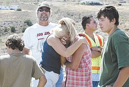 Kim Proctor, center, is hugged by neighbor Sandy Offenstein after learning her dog died in a fire on Monday.  From left, Adam Insell, Larry Offenstein, Ole Chavez and Apalo Insell also rushed to help when the fire started.