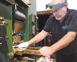 Ken Hopple works on the Carson City Mint&#039;s Press on Monday at the Nevada State Museum minting brass coins depicting the Virginia &amp; Truckee Railroad.