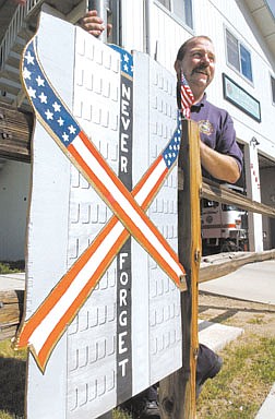 East Fork Fire and Paramedic District Company Officer John Bellona stands next to the 9/11 memorial they have posted outside the Indian Hills Firestation.