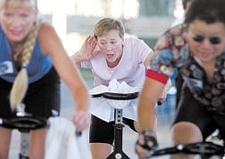 Kimberley Dehart, center, chats with a friend during a spinning class at Mills Park Pavillion Saturday. Jill Silva, of Reno, and Monte Lee, of Carson ride.