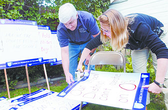 Dave Pitts and Willow Evans put put together a pickett sign which reads &#039;Our school system can&#039;t operate on 0%&#039;  during   Wednesday at the home of school district employee.  photo by Rick gunn