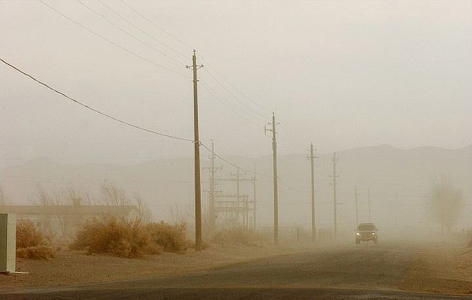 Rick Gunn/Nevada Appeal a lone car drives through a section of the dust storm on the backstreets of Mark Twain Tuesday afternoon. The wind driven dust reduced visibility causing the closure of Highway 50 east near Boyer Rd.
