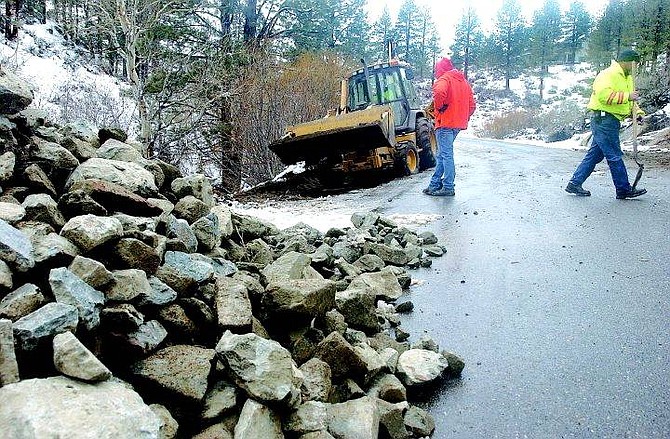 Rick Gunn/Nevada Appeal Carson City road workers pack fill dirt into a section of Old Clear Creek Road Thursday afternoon eroded during a recent storm.