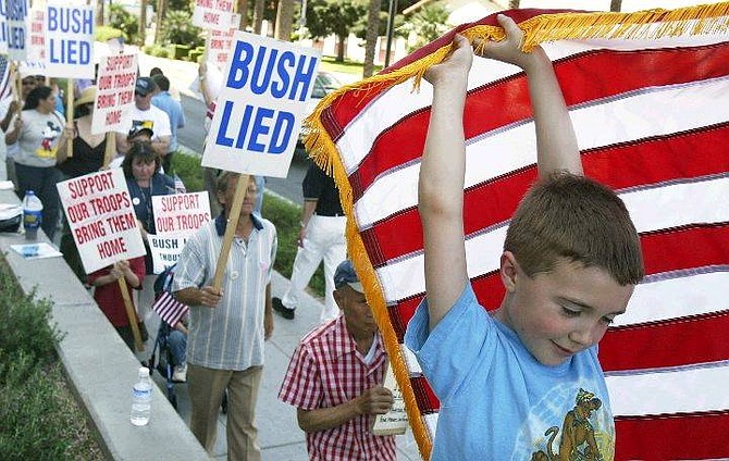 Brandon Skorzanka, 7, helps hold up a flag during an anti-war rally in front of the Lloyd D. George United States Courthouse in Las Vegas, Saturday, March 20, 2004.  Thousands of protesters turned out nationwide Saturday to mark the first anniversary of the start of the U.S.-led war on Iraq and call for the removal of American troops from the Middle East country. (AP Photo/Las Vegas Review-Journal, John Locher)