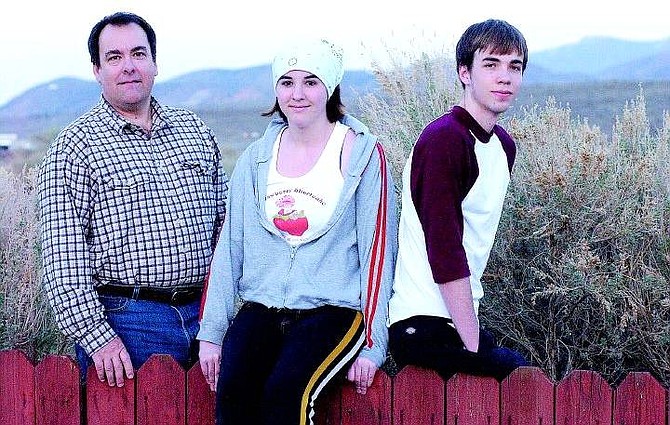 Rick Gunn/Nevada Appeal Jason Clark stands with his niece Caitlin Berger, 14, and Kyle Berger, 15, in front of their Carson City home. Clark, a crew member on the movie, &quot;Hidalgo,&quot; coordinated roles as extras for the two Carson High School students.