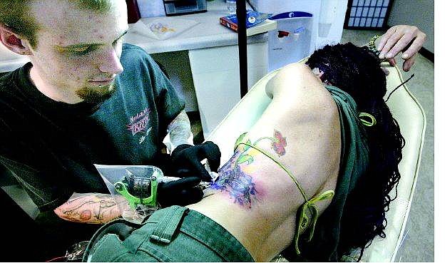 Cathleen Allison/Nevada Appeal Tattoo Revolution artist Jamie Thornley works on Mira Luna on Monday afternoon at the East Carson City salon.