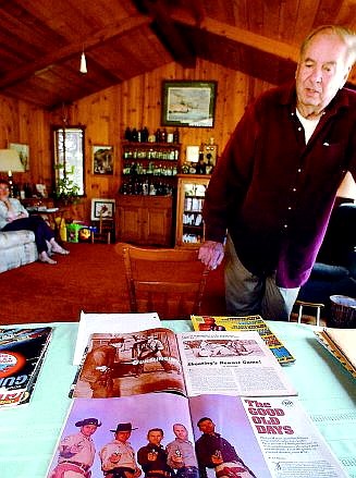 Rick Gunn/Nevada Appeal Former Southern California law enforcement officer Jack Weaver looks over a number of magazine articles written about him at his home in Indian Hills. Jack was the first one to use a two-handed handgun stance, commonly used by law enforcement today. At top right, a poster of Weaver demonstrating his stance.