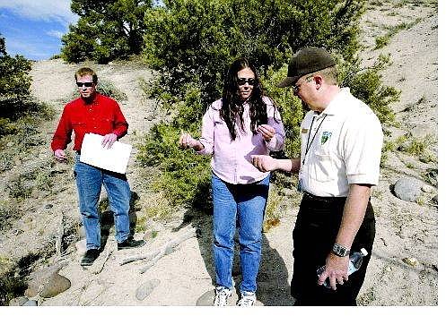 Cathleen Allison/Nevada Appeal Bureau of Land Management spokesman Mark Stuble, right, looks at 3 million-year-old bone fragments with archaeologist Susan McCabe and Nate Littrell of the Pine Nut Mountains Trail Association in the Pine Nuts south of Gardnerville on Thursday morning. At top, Stuble shows a 3 million-year-old bone fragment from a mastadon found in the Pine Nut Mountains.