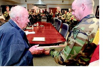 Rick Gunn/Nevada Appeal Army National Guard State Commander Sgt. Maj. Stephen Sitton presents former Nevada state senator Lawrence &#039;Jake&#039; Jacobsen a plaque full of commemorative military coins at a ceremony at the Army National Guard headquarters in Carson City on Friday.