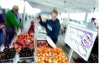Rachel Reilly of Matthew&#039;s Family farm of Yuba City  hands out fresh fruit at the first Farmers Market of the year at the Pony Express Pavillion Wednesday afternoon.