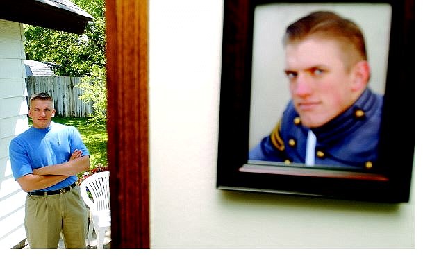 BRAD HORN/Nevada Appeal Ehren Miller stands in the back yard of his Carson City home with a picture of the Army second lieutenant hanging on the wall in the foreground. Miller, a 2000 Carson High graduate, graduated from the U.S. Military Academy at West Point this month.