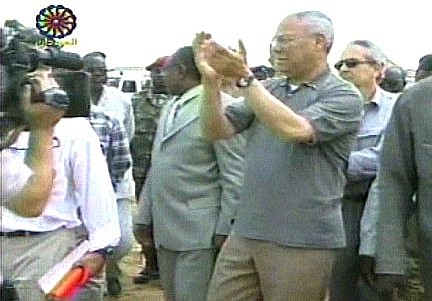 In this image from televsion Secretary of State Colin Powell claps as he and his group approaches a group of villagers in Al-Fasher, in the western province of Darfur in the Sudan, Wednesday, June 30, 2004. Powell came to tour camps and press the government to end ethnic violence and a humanitarian crisis he has called &quot;catastrophic.&quot; (AP Photo/Sudanese TV via APTN)