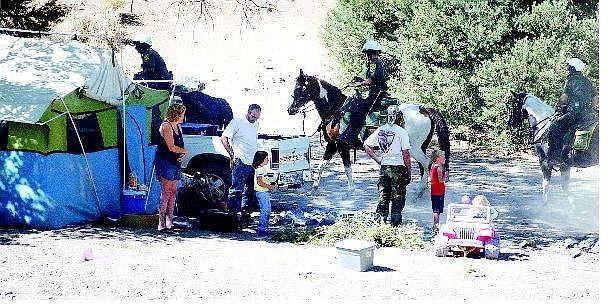 BRAD HORN/Nevada Appeal Transients including Michael Hesse, center with back turned, watch as Carson City sheriff&#039;s deputies leave their campsite after warning them they have one week to vacate the area or face trespassing charges. Below, an unidentified couple comfort each other with a hug after the warning.