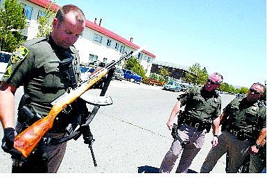 BRAD HORN/Nevada Appeal Carson City Sheriff Deputy Gary H. Underhill holds the SKS Russian assault rifle that was fired twice from an apartment&#039;s balcony in Carson CIty on Saturday. Below is suspect Manual Vargas-Rangel, 41, who was arrested on suspicion of firing an assault rifle near children at a swimming pool.
