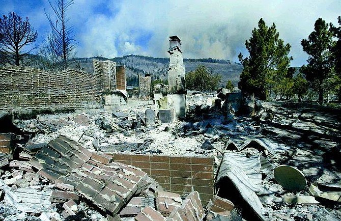 The Waterfall Fire continues to burn out of control Thursday, July 15, 2004, in Carson City, Nev. after destroying more than 8,500 acres and 21 structures.  This home in Kings Canyon was one of several lost Wednesday in a firestorm that destroyed several fire trucks and injured firefighters.  (AP Photo/Nevada Appeal, Cathleen Allison)