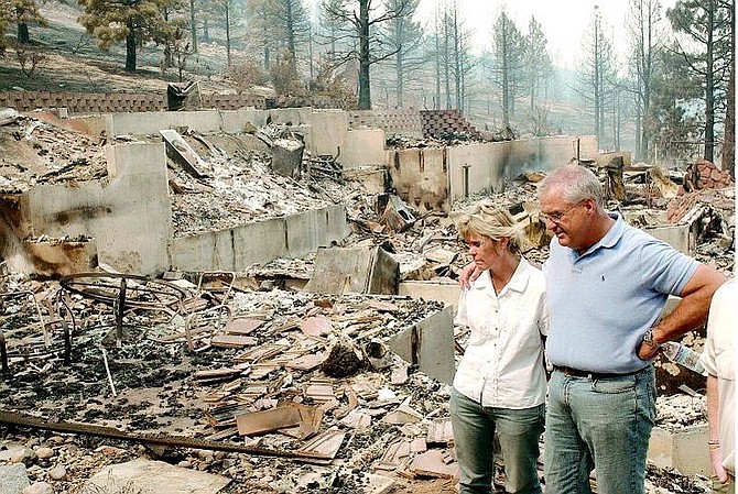 Rick Gunn/Nevada Appeal Chuck and Karen Schardin stand near the remains of their home on Timberline Drive Friday. They lost their home to the  Waterfall Fire Thursday evening.